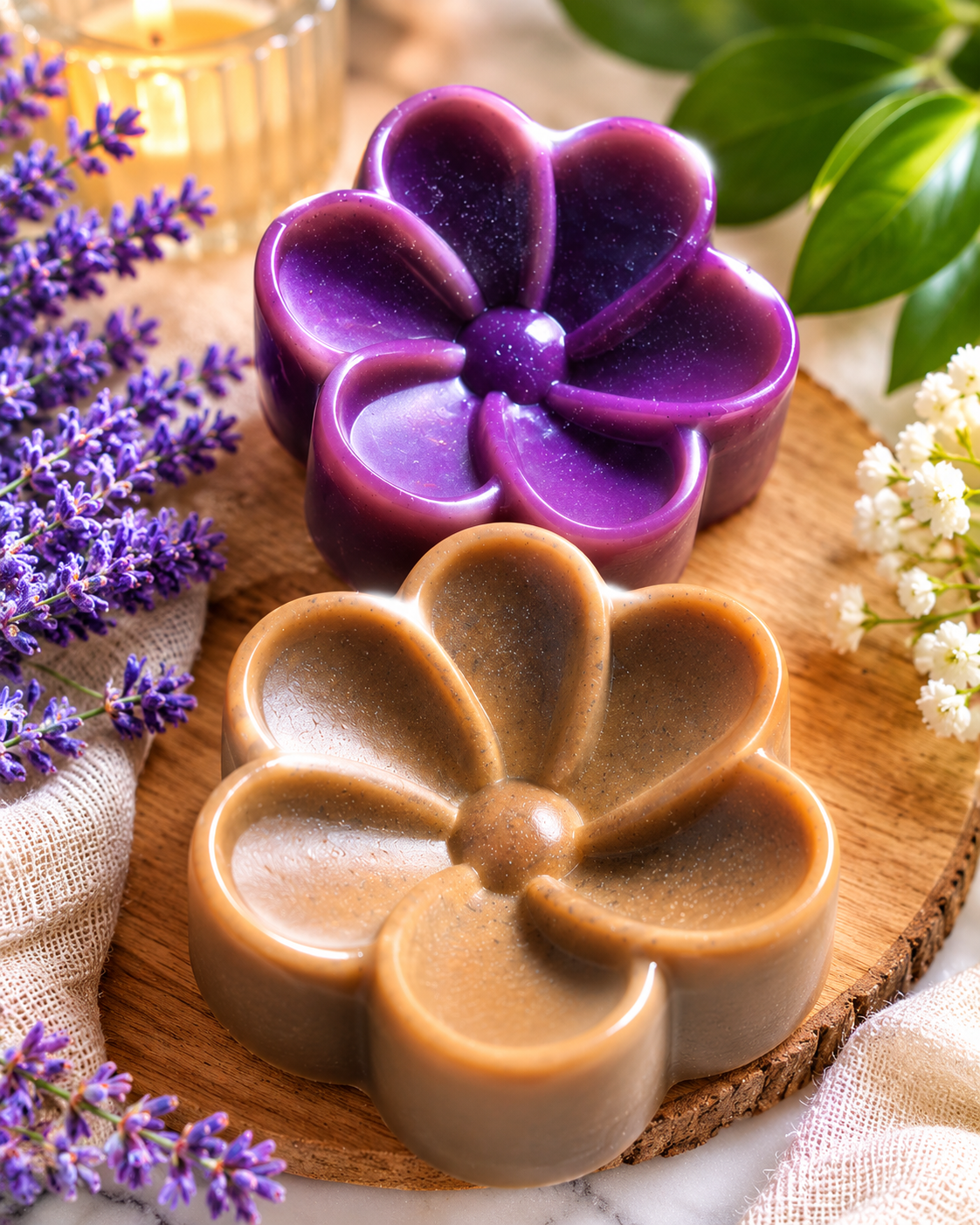 Jabones artesanales naturales en forma de flor, decorados con flores de lavanda y plantas verdes.