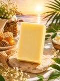 Jabón artesanal con miel vitamina E en un entorno natural con luz de sol y decoración floral.